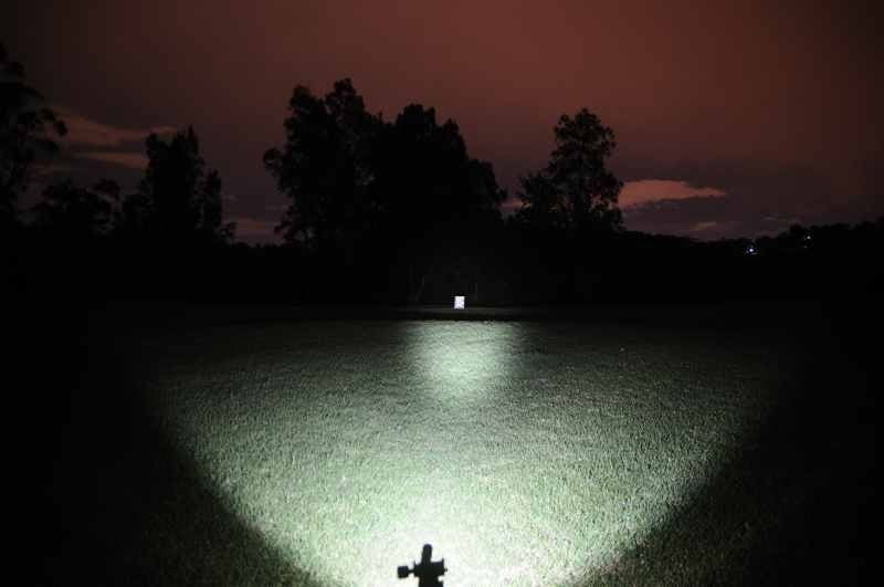 Beam output of Angel C LED Torch - Compact Powerful Light | 260 Lumens, Rechargeable showing wide, bright illumination with 60m throw in outdoor setting.