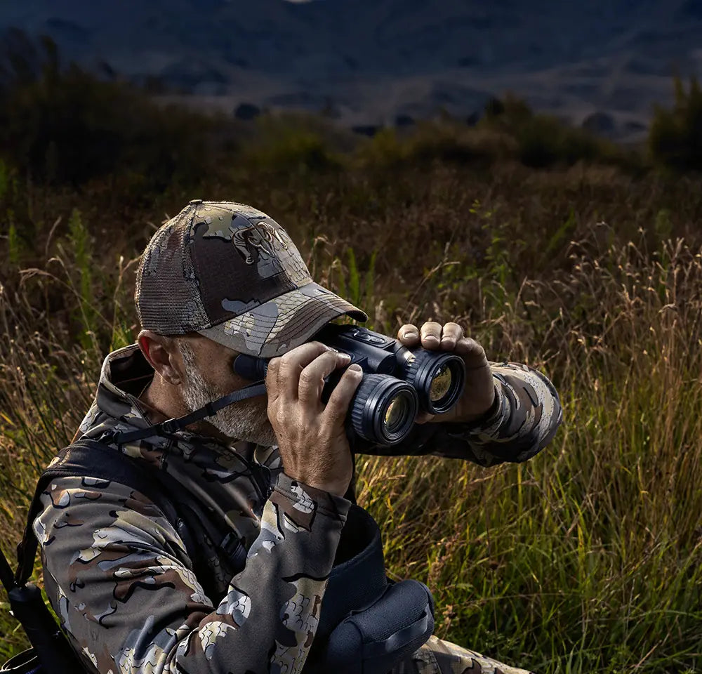 pulsar thermal binoculars in use by a camouflaged man