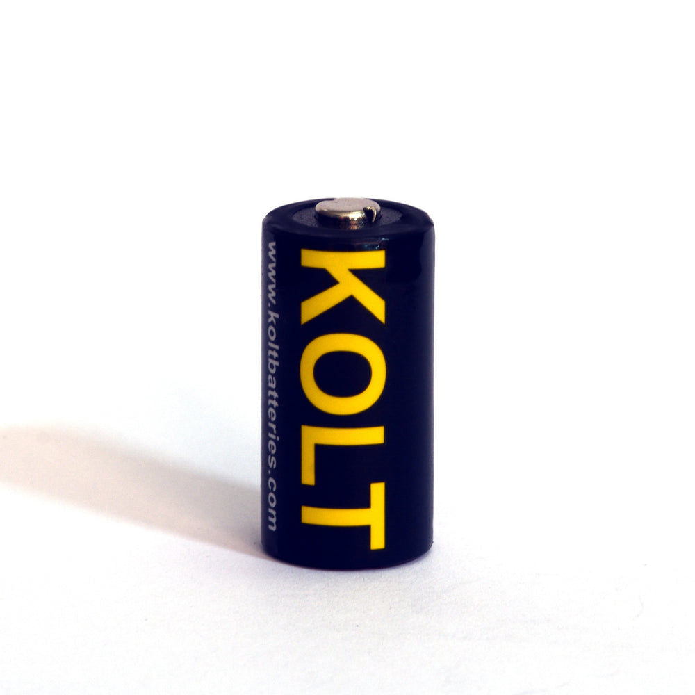 Single Kolt CR123A battery standing upright with yellow branding and website. Compact 3V lithium battery for high-drain electronics.